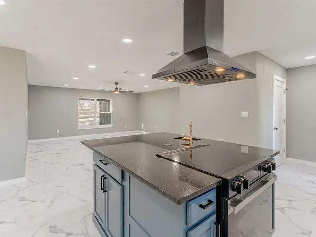 a large kitchen with kitchen island stainless steel appliances a sink a stove and a refrigerator