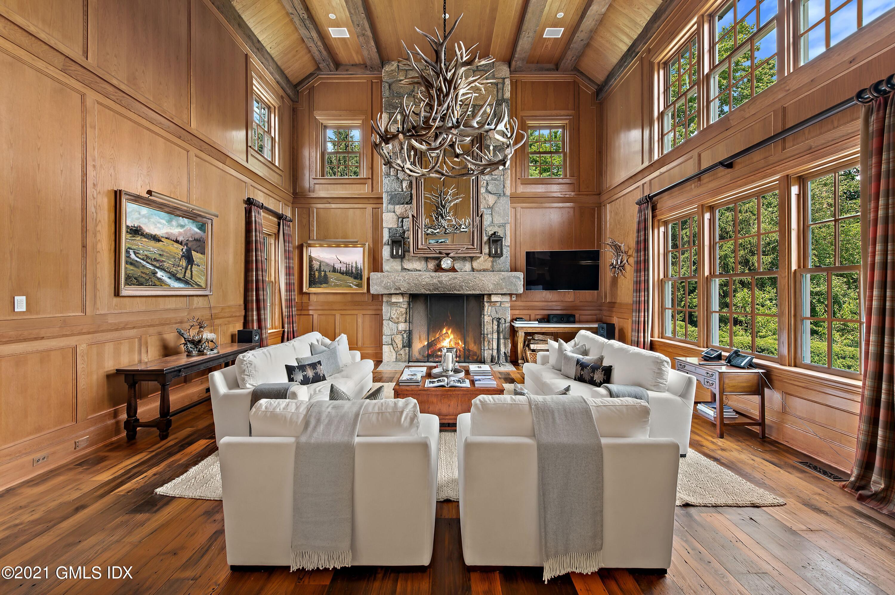 435 Round Hill Road Greenwich, CT 06831 - Photo 14 of 44 a living room with fireplace furniture large windows and wooden floor