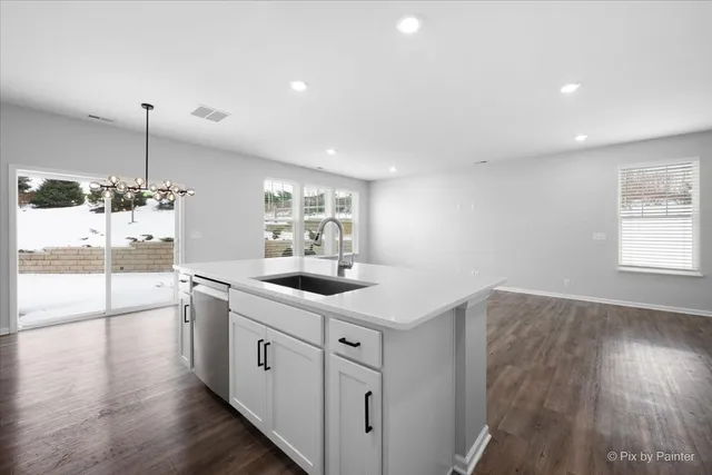 a kitchen with a sink and wooden floor