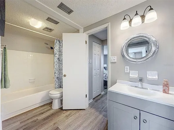 a bathroom with a toilet sink double vanity and bathtub