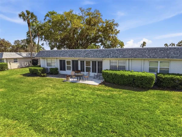 a view of house with a big yard and potted plants