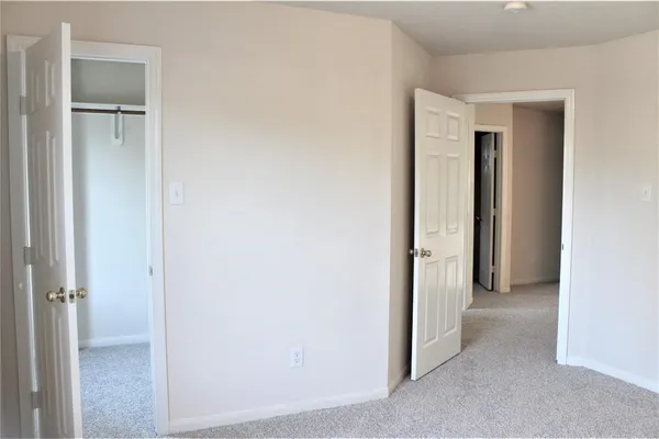 a view of a hallway with closet and a room