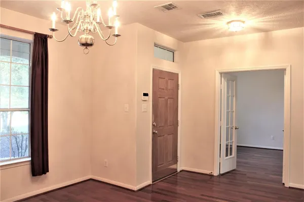 a view of a hallway with wooden floor and a chandelier