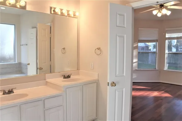 a bathroom with a sink vanity granite tub and shower