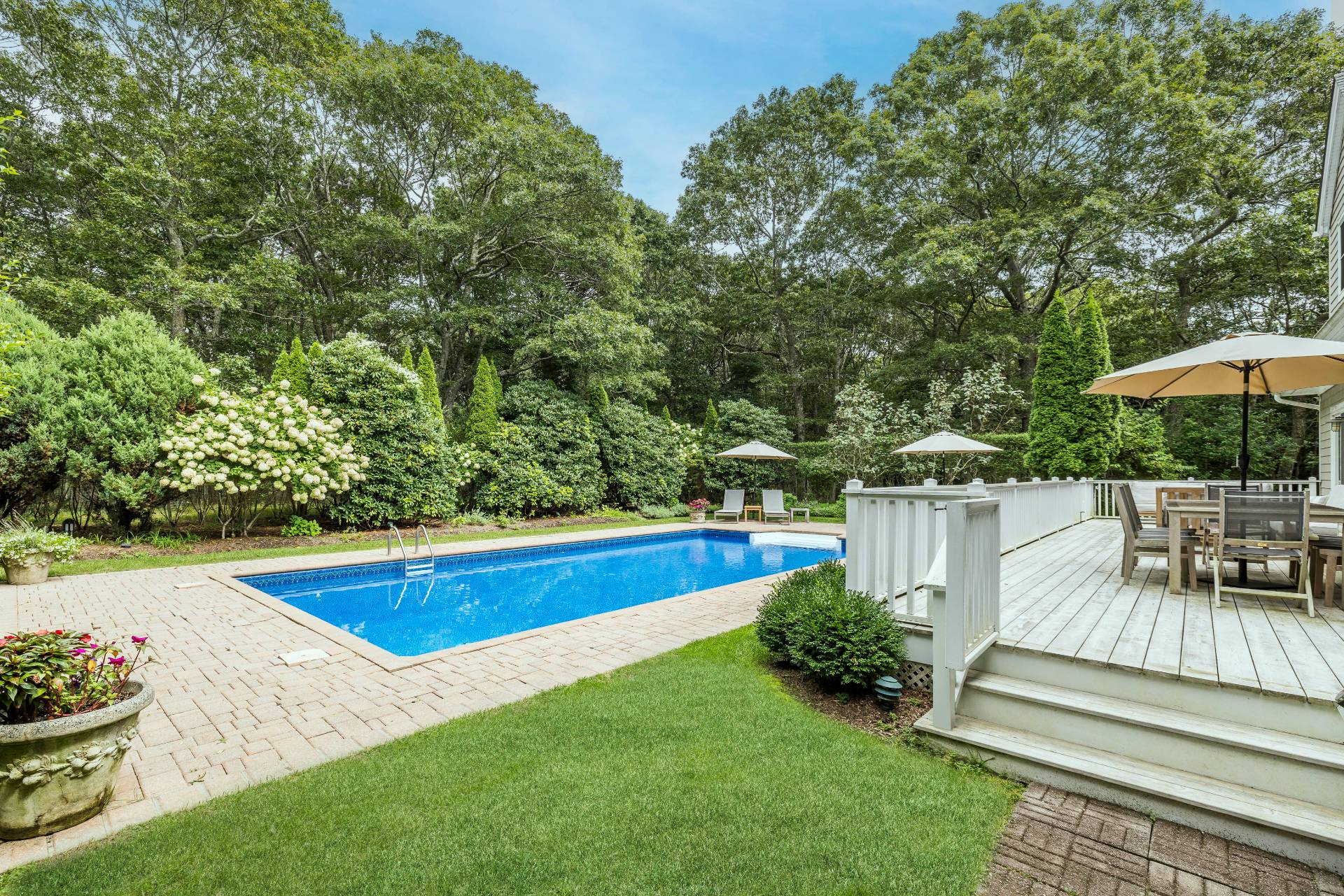 9 Central Avenue East Hampton, NY 11937 - Photo 1 of 21 a view of swimming pool with lawn chairs under an umbrella