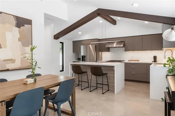 a kitchen with a table chairs and a refrigerator