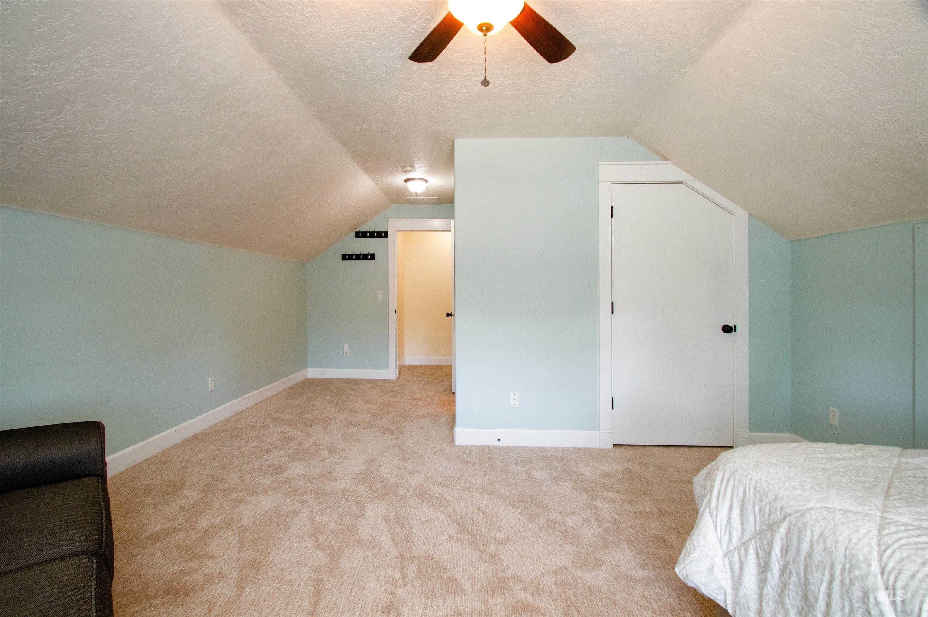 892 South Capitola Way Boise, ID 83712 - Photo 20 of 34 Sloped ceiling room featuring light blue walls, neutral-toned carpeting, and a ceiling fan with integrated lighting