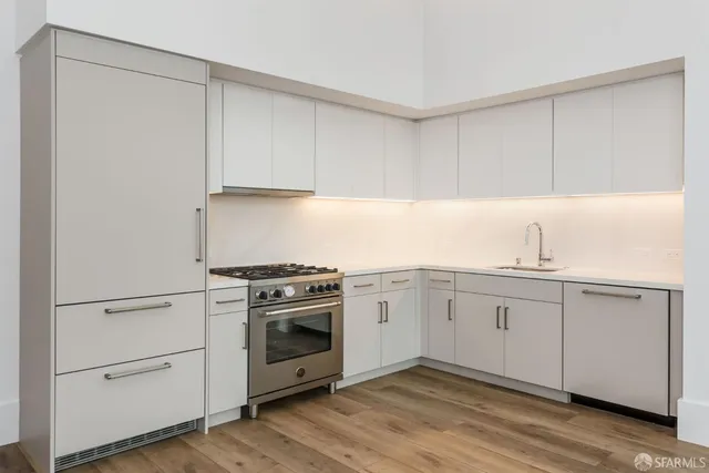 a kitchen with granite countertop white cabinets and a sink