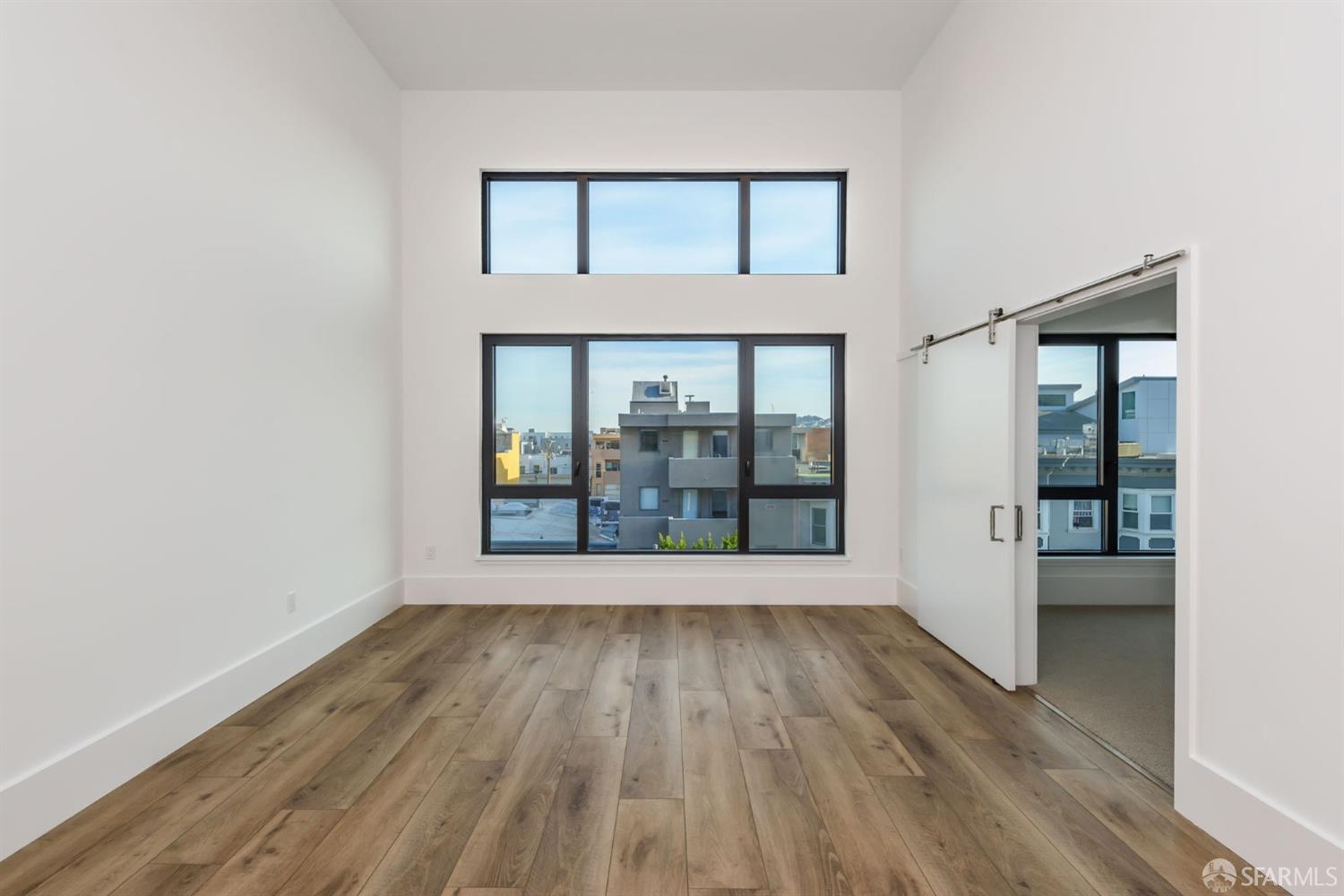 1288 Howard Street, Unit 509 San Francisco, CA 94103 - Photo 9 of 55 a view of an empty room with wooden floor and a window