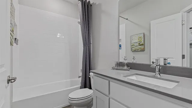 a bedroom with a bed and a lamp on the dresser