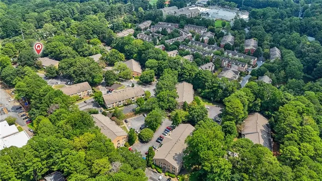an aerial view of a house with a yard and trees all around