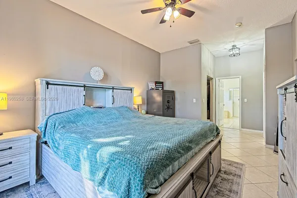 a bedroom with a large bed a chandelier and closet