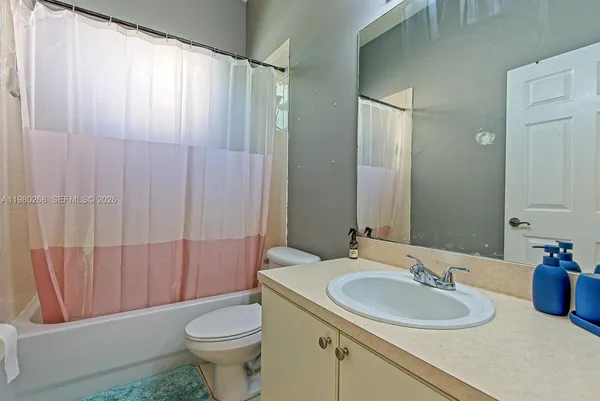 a bathroom with a sink a toilet and shower curtain