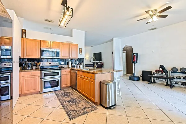 a kitchen with stainless steel appliances granite countertop a refrigerator and a stove top oven