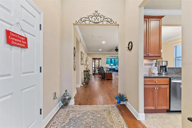 a view of a hallway with wooden floor and a livingroom