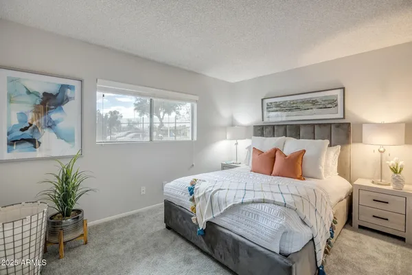 a bed sitting in a bedroom next to a lamp