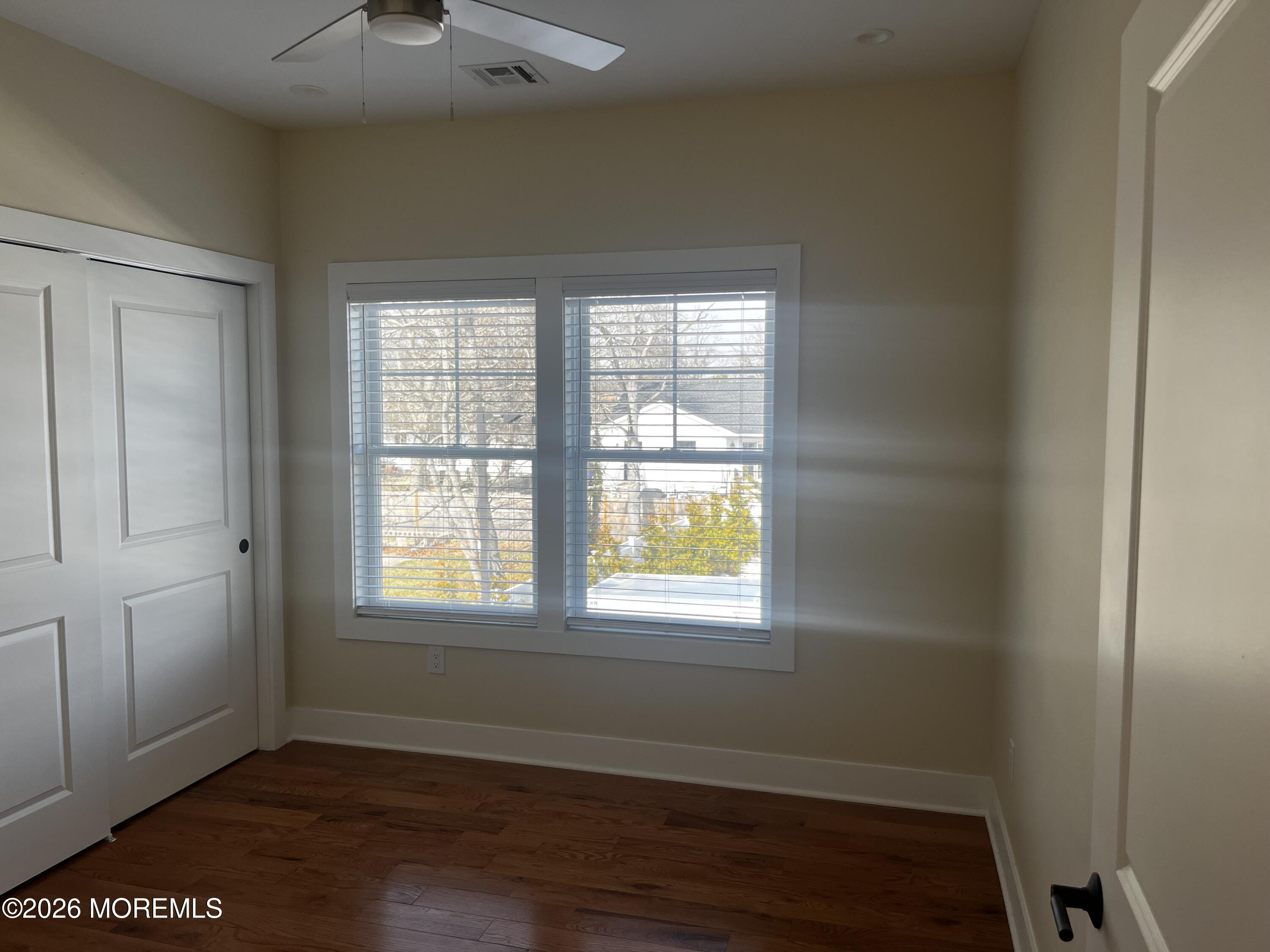 2419 Bridge Avenue, Unit 201 Point Pleasant, NJ 08742 - Photo 4 of 7 a view of an empty room with wooden floor and a window
