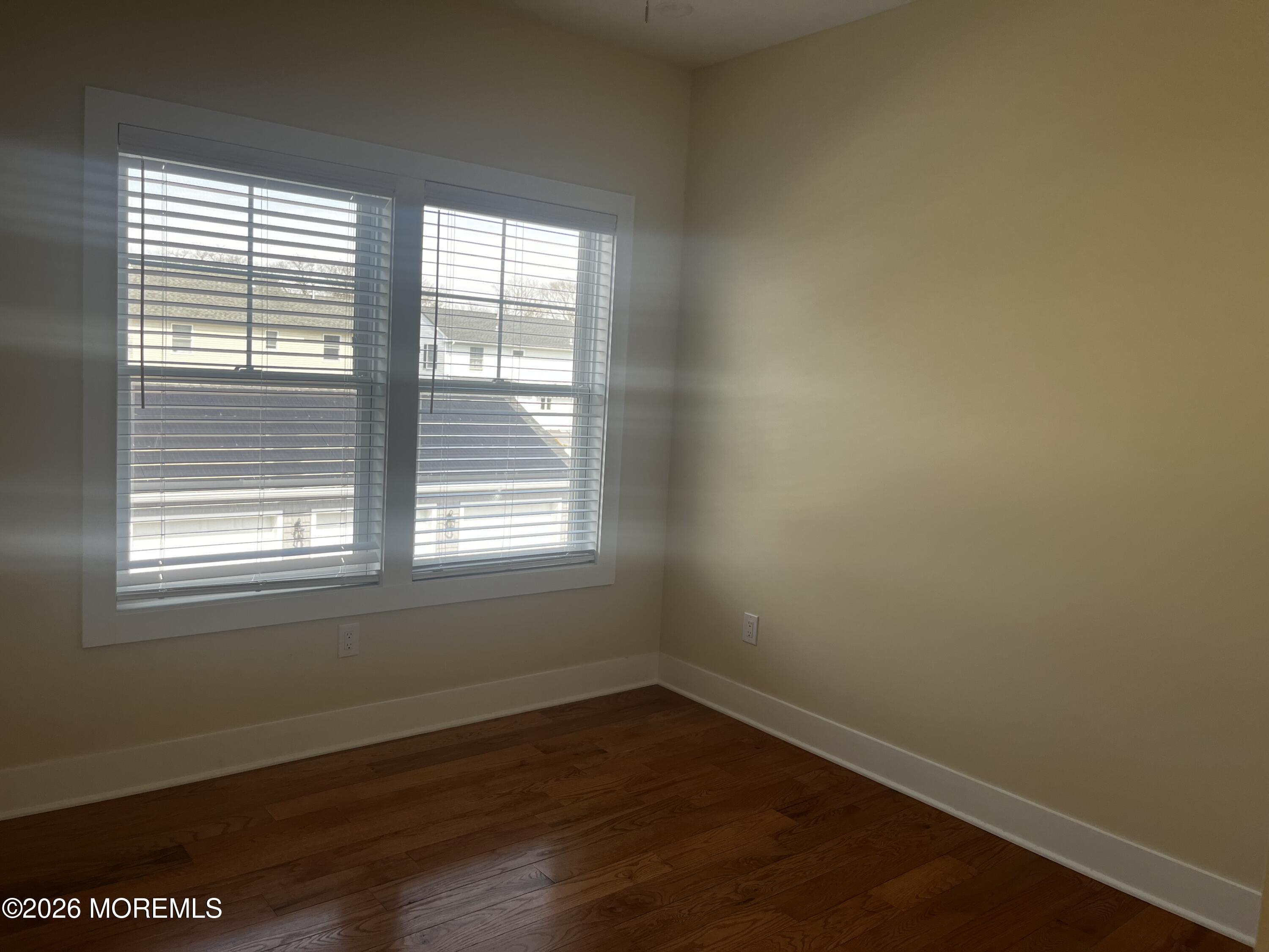 2419 Bridge Avenue, Unit 201 Point Pleasant, NJ 08742 - Photo 5 of 7 an empty room with wooden floor and windows