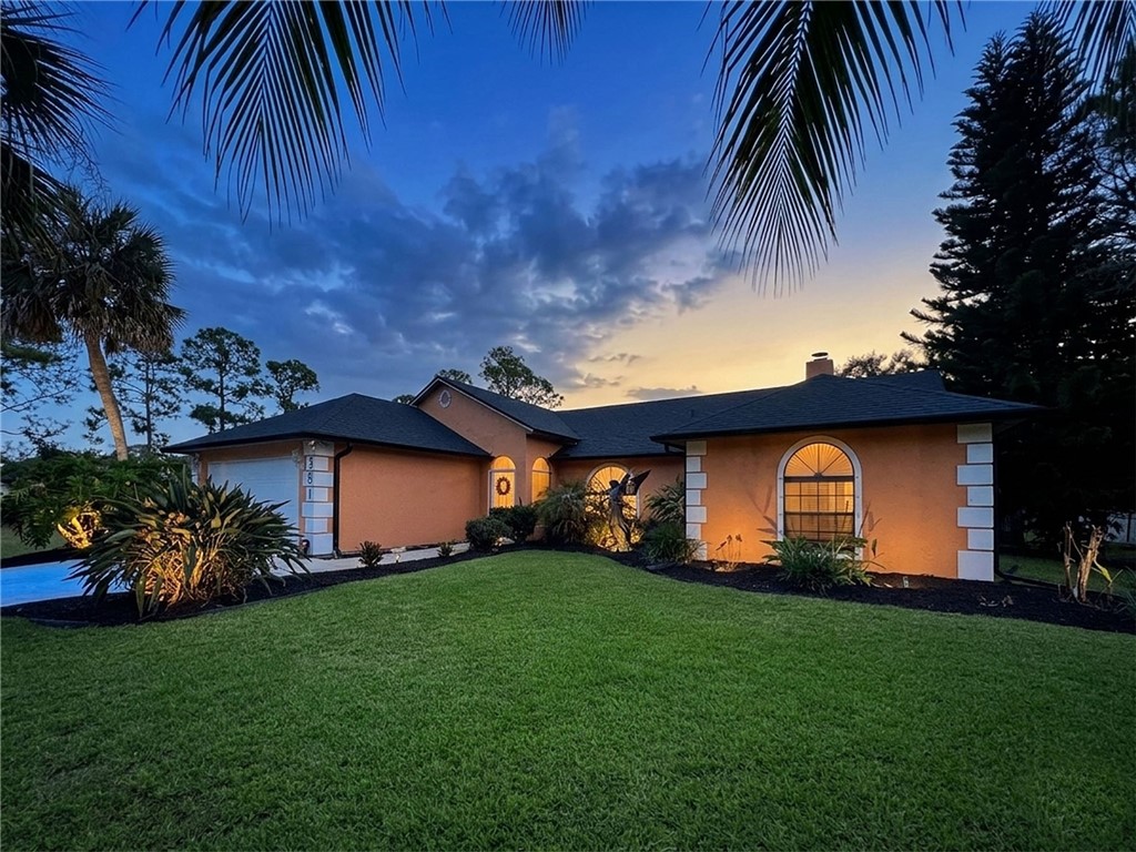 a front view of a house with a garden and plants