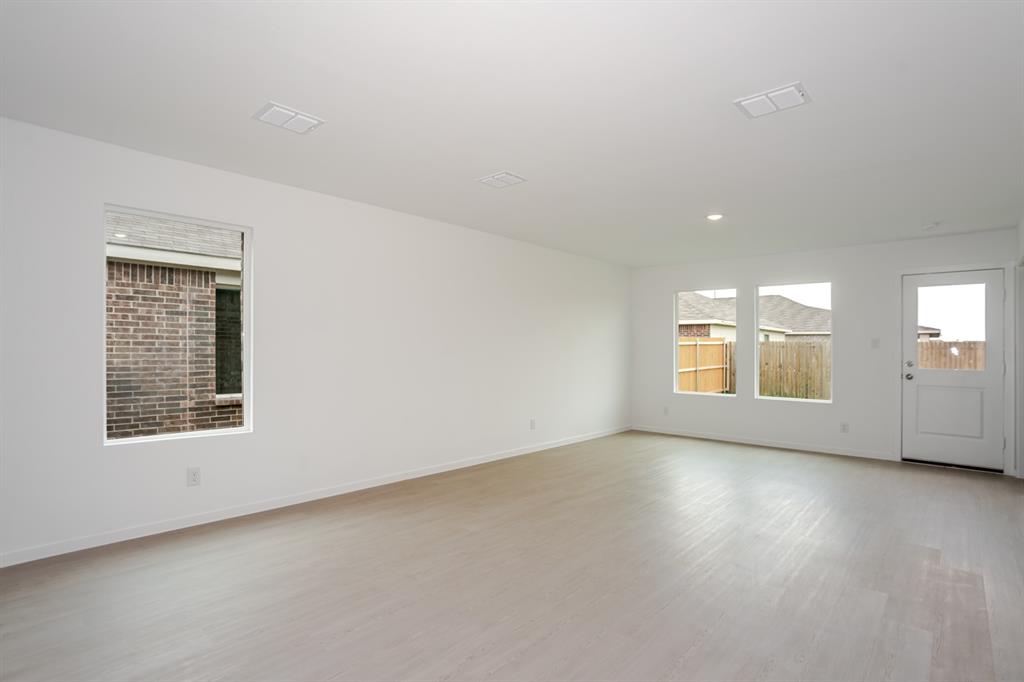 1419 Merlin Blf Street Forney, TX 75126 - Photo 6 of 24 Spacious interior room featuring light wood-finish flooring, white walls, and multiple windows