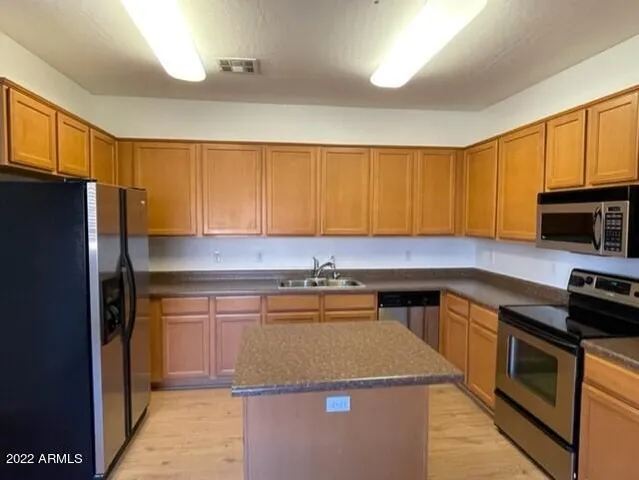 a kitchen with stainless steel appliances granite countertop a stove a refrigerator and a microwave