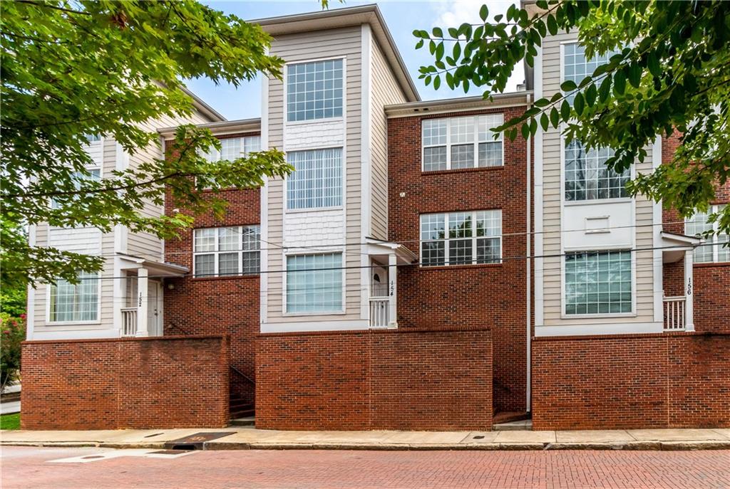 a front view of a house with a tree