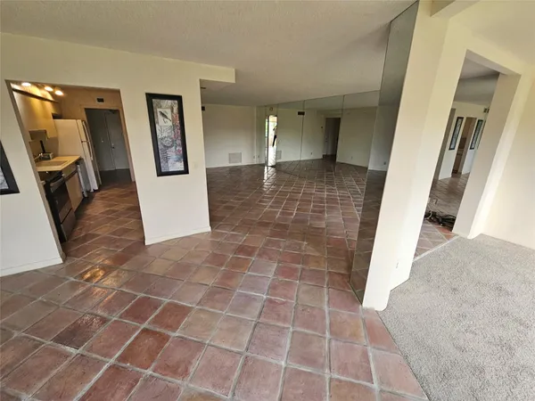 a view of a hallway with wooden floor and a bathroom
