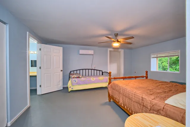 a spacious bedroom with a bed and a window