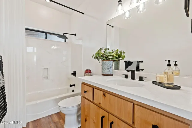 a bathroom with a sink a toilet and shower