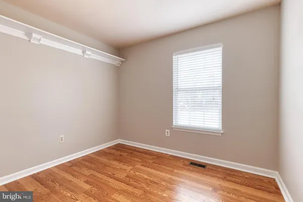 a view of a room with wooden floor and a window