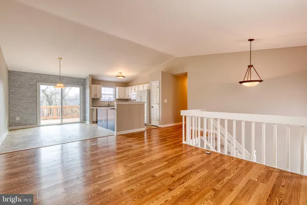 a view of a livingroom with wooden floor and staircase