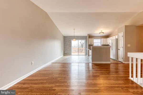 a view of empty room with wooden floor and windows
