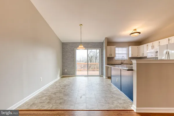 a kitchen with stainless steel appliances granite countertop a refrigerator a sink dishwasher a stove with wooden cabinets and floor