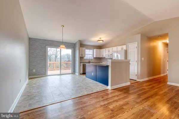 a view of a kitchen with wooden floor and a kitchen