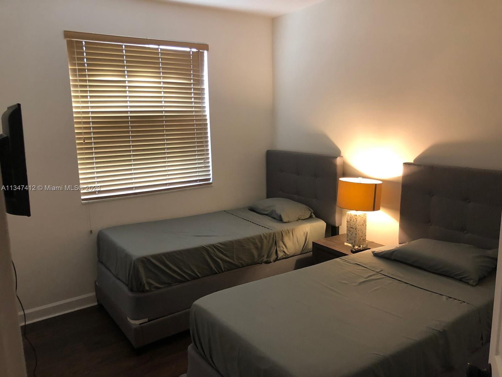 10836 Southwest 245th Street Homestead, FL 33032 - Photo 13 of 18 a bedroom with two beds and a window