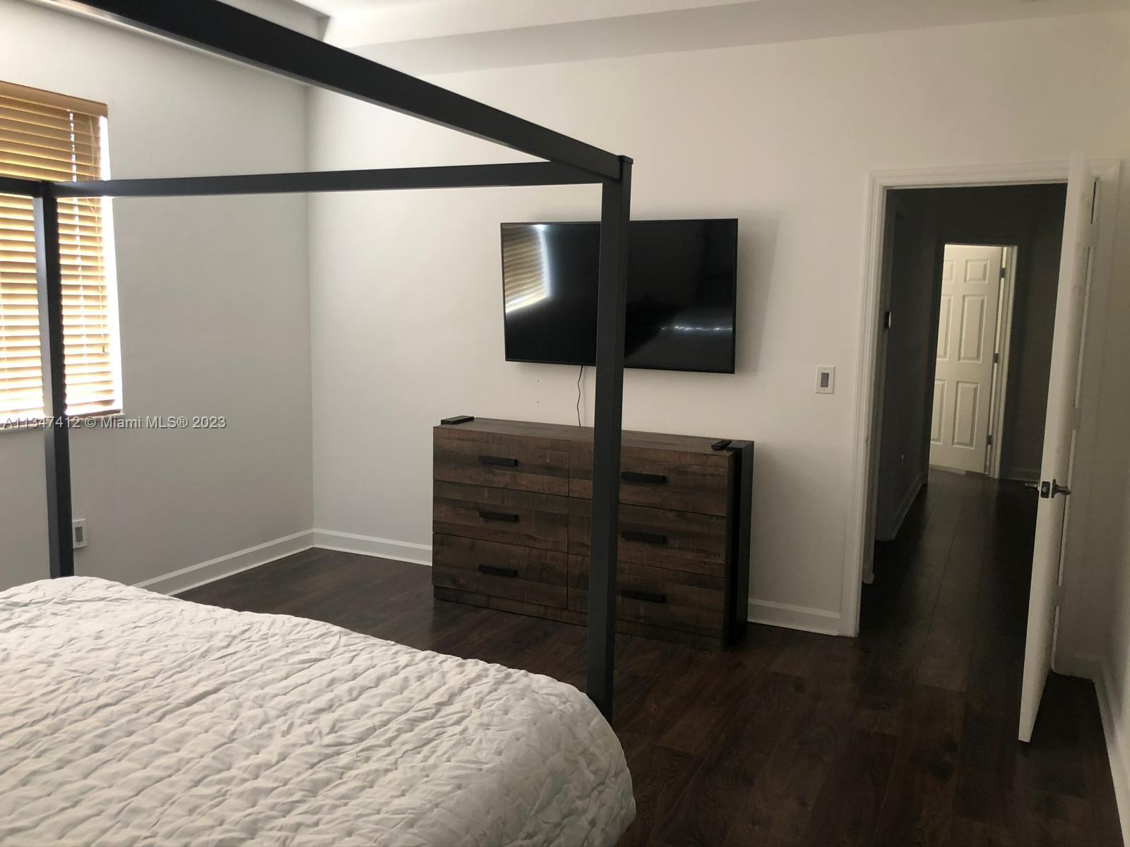 10836 Southwest 245th Street Homestead, FL 33032 - Photo 16 of 18 a bedroom with a bed and a flat screen tv