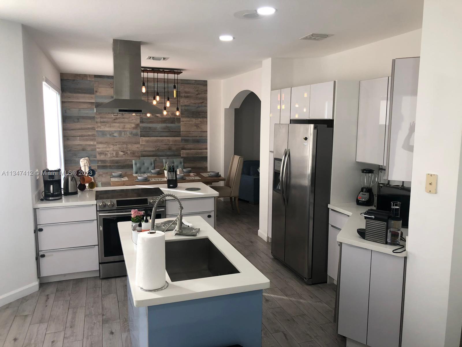 10836 Southwest 245th Street Homestead, FL 33032 - Photo 2 of 18 a kitchen with a refrigerator sink and cabinets
