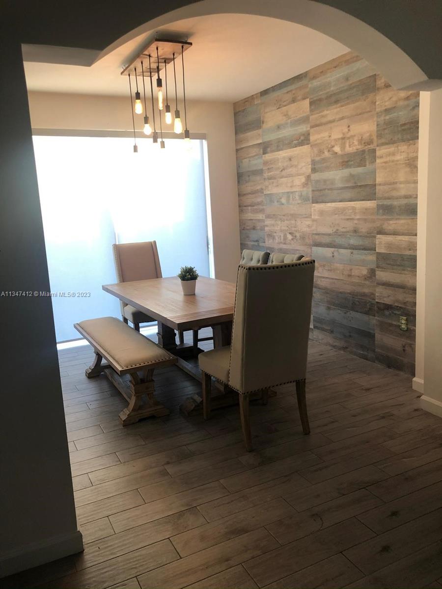 10836 Southwest 245th Street Homestead, FL 33032 - Photo 3 of 18 a view of a dining room with furniture and wooden floor