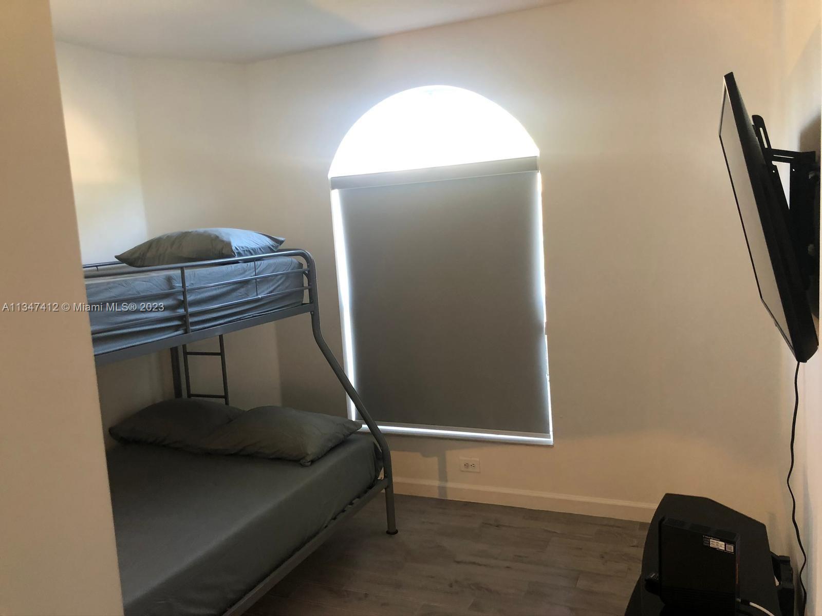 10836 Southwest 245th Street Homestead, FL 33032 - Photo 10 of 18 a bedroom with a bed and a mirror