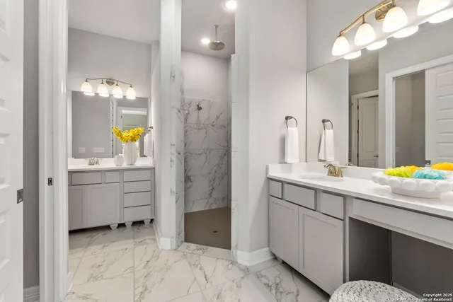 a bathroom with a granite countertop sink two mirror and a vanity