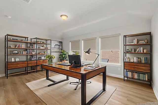 a view of a workspace with furniture and wooden floor