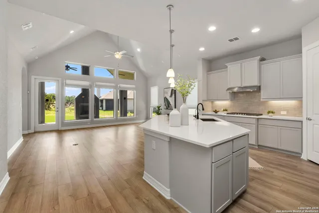 a kitchen with a sink and wooden floor