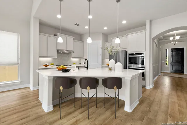 a kitchen with stainless steel appliances kitchen island granite countertop a sink and cabinets