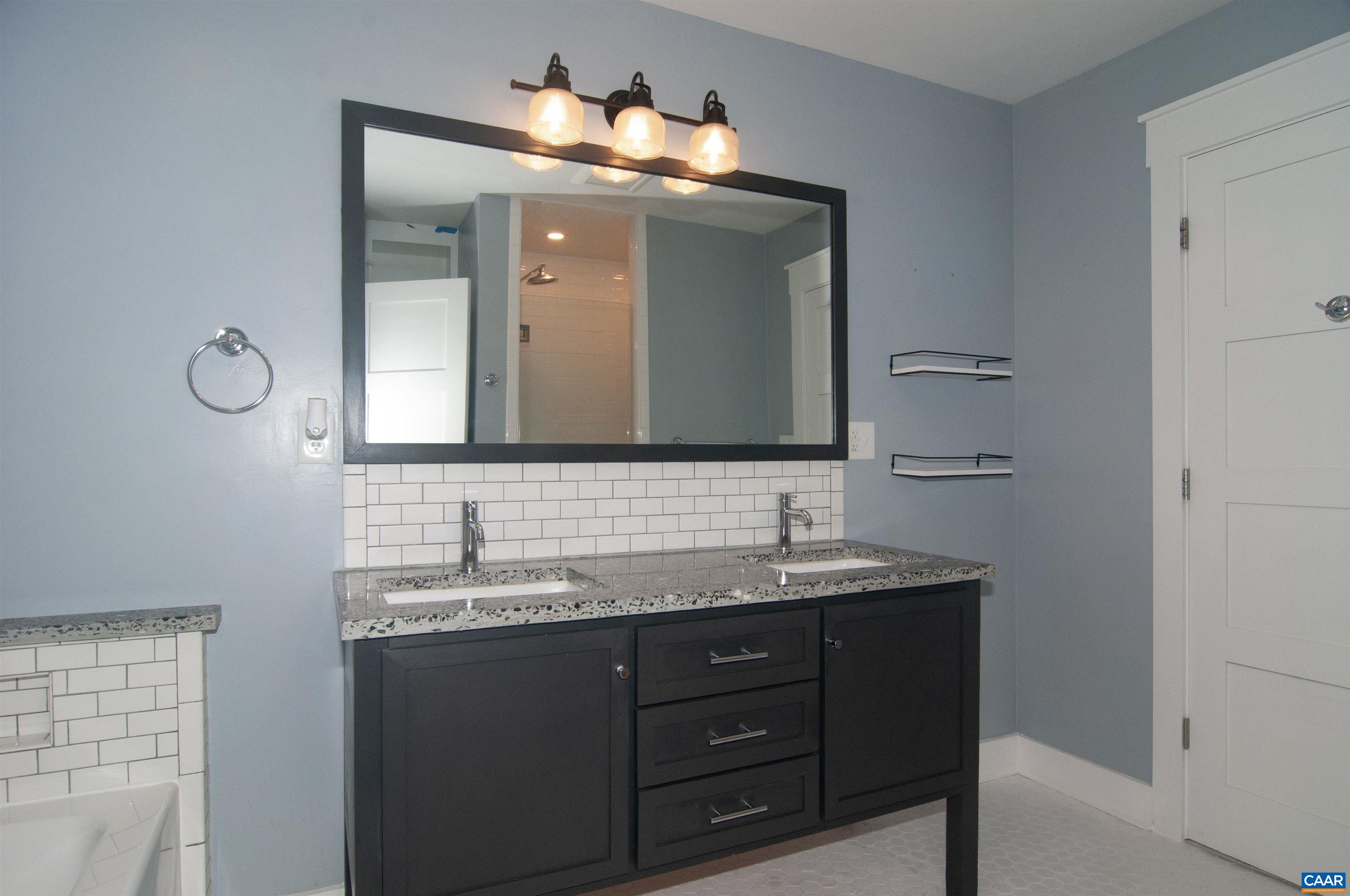 4600 Advance Mills Road Earlysville, VA 22936 - Photo 30 of 61 a bathroom with a granite countertop sink a large mirror and a shower