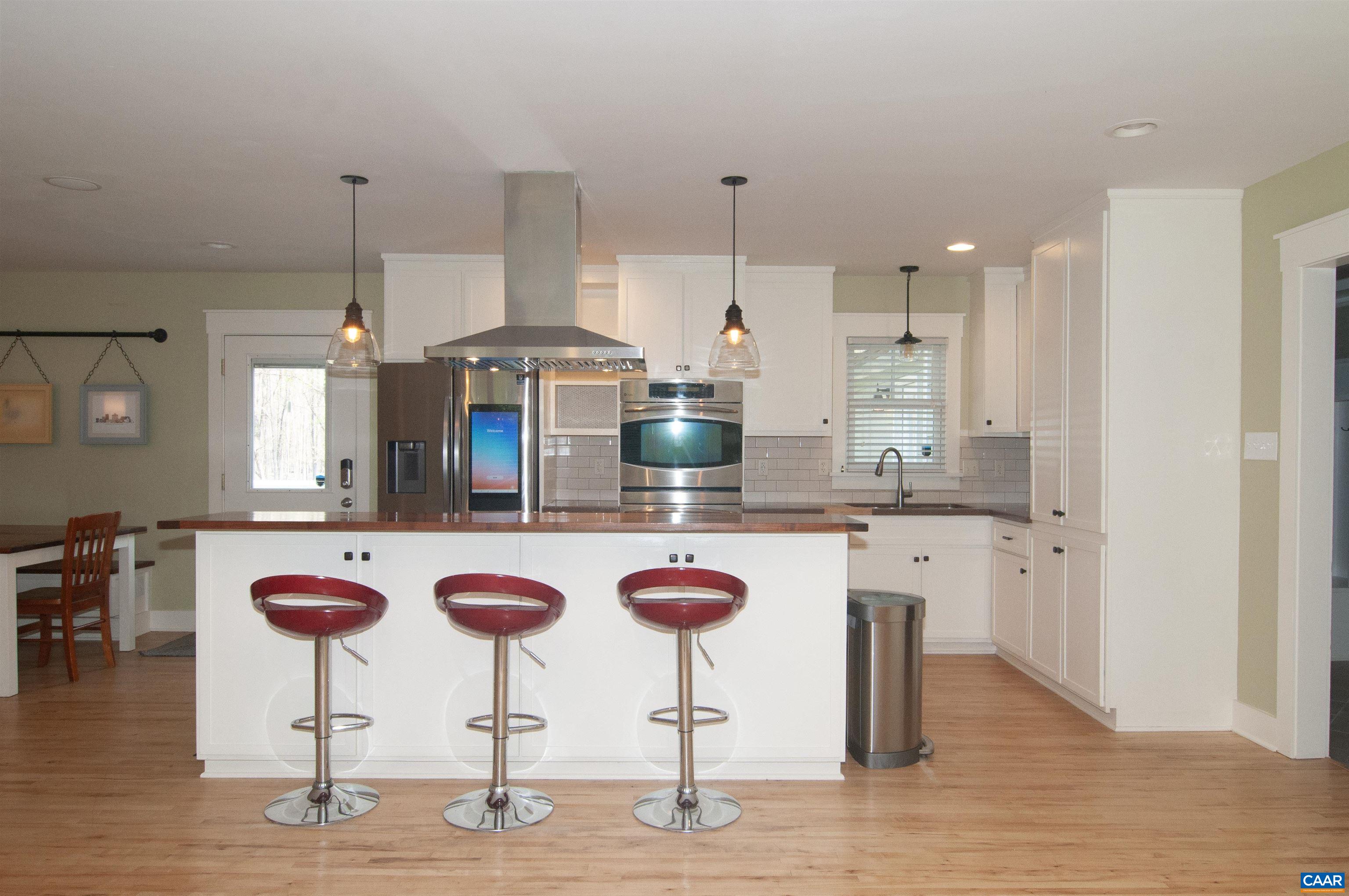 4600 Advance Mills Road Earlysville, VA 22936 - Photo 6 of 61 a kitchen with stainless steel appliances kitchen island granite countertop a table chairs in it and wooden floors