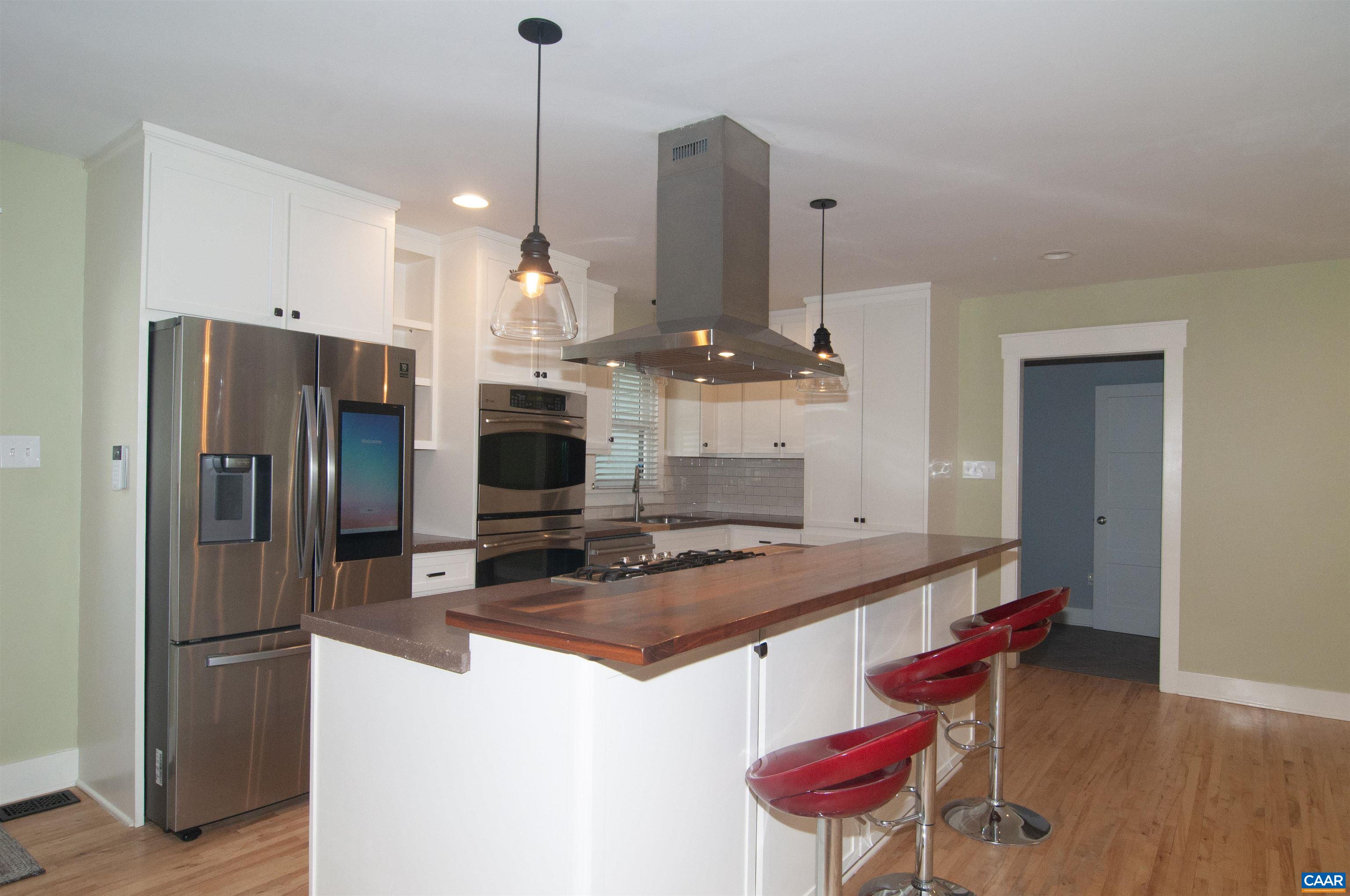 4600 Advance Mills Road Earlysville, VA 22936 - Photo 7 of 61 a kitchen with stainless steel appliances kitchen island granite countertop a refrigerator a stove and white cabinets with wooden floor