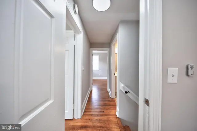 a view of a hallway with wooden floor and staircase