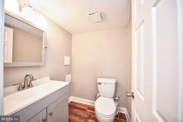 a bathroom with a toilet a sink a mirror and vanity