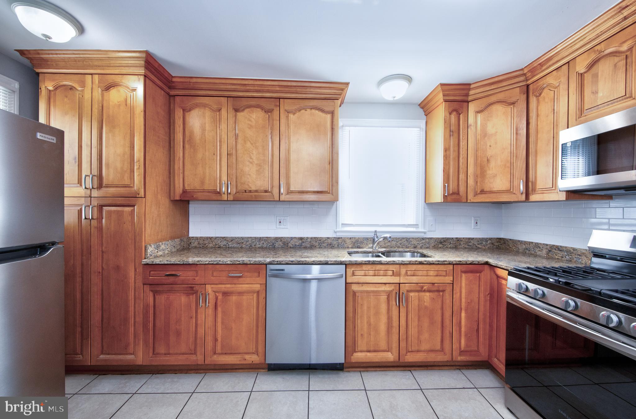 2326 Ivy Avenue Baltimore, MD 21214 - Photo 9 of 30 a kitchen with stainless steel appliances granite countertop a stove a sink and a microwave