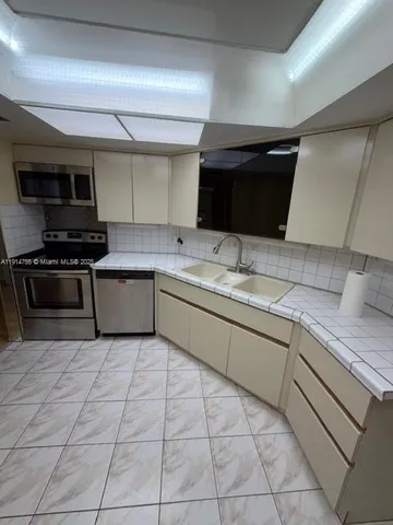 a kitchen with stainless steel appliances granite countertop a sink and a stove top oven